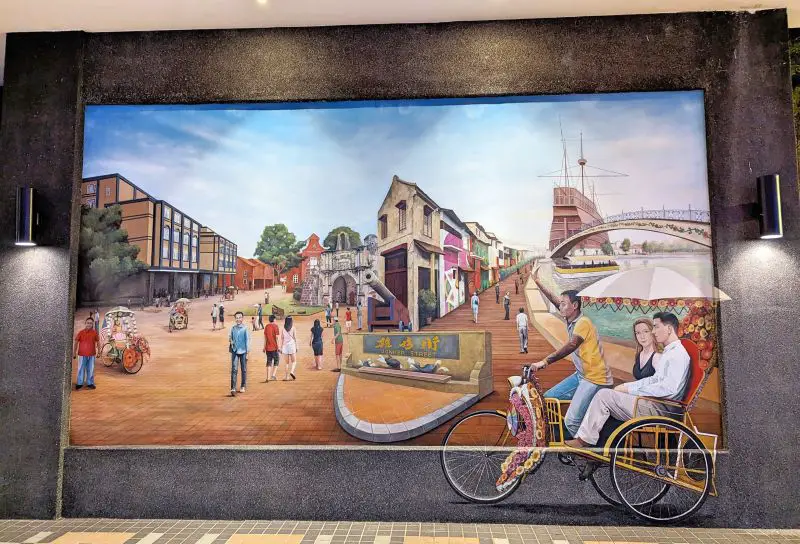 A wall mural in front of the Ibis Melaka Hotel of the Melaka cultural attractions and sights such as the rickshaws, A Formosa, pirate ship, and more