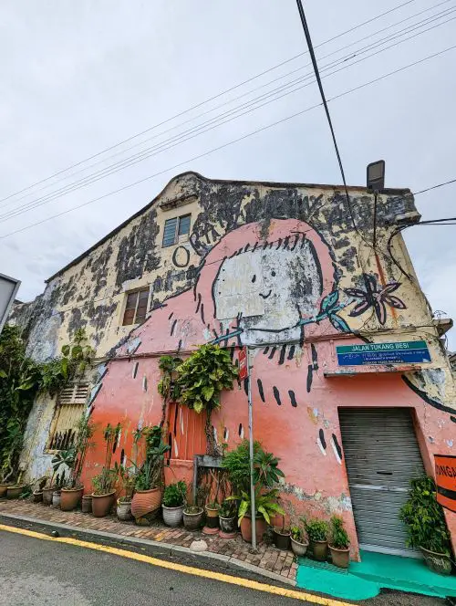 A giant orange orangutan covering the side of a building in Melaka, Malaysia