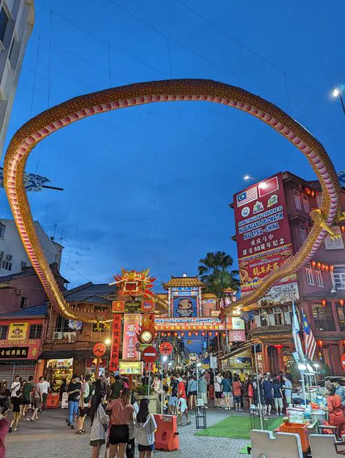 A dragon's body and head in front of the Jonker Street Night Market entrance in Melaka, Malaysia