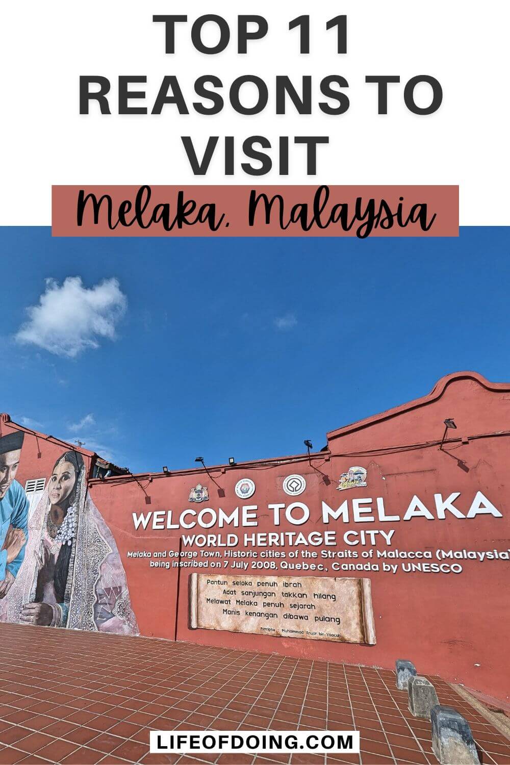 A red brick colored wall with a Welcome to Melaka World Heritage City sign and murals of a Malaysian man and woman