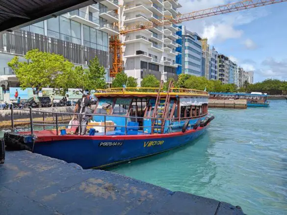 A blue, red, and yellow ferry at the Male’s Henveiru Ferry Terminal dock