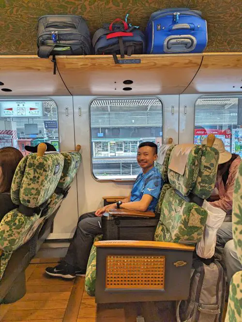 Justin Huynh, Life Of Doing, sits on the Yufuin no Mori train and the overheat space has our three carry on luggages