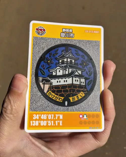 A hand holding a manhole card of Kakegawa Castle from Kakegawa, Japan