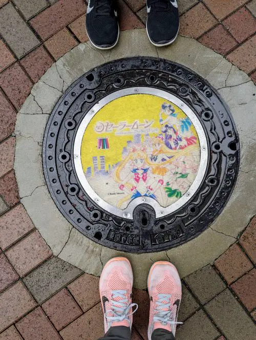 Life Of Doing stands around the yellow manhole cover of Sailor Moon and Sailor Guardians