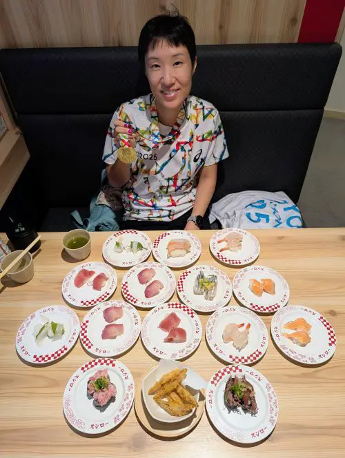Jackie Szeto, Life Of Doing, wears her Tokyo Marathon t-shirt and finisher's medal at Sushiro, the a post-marathon race meal