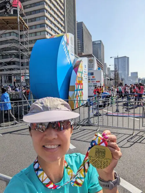 Jackie Szeto, Life Of Doing, takes a selfie with her finisher's medal at the Tokyo Marathon 2025 finish line