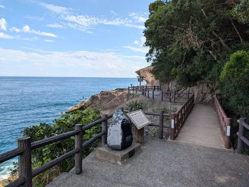 A walking path at the entrance of the Onigajo Cliffside Entrance and a view of the ocean