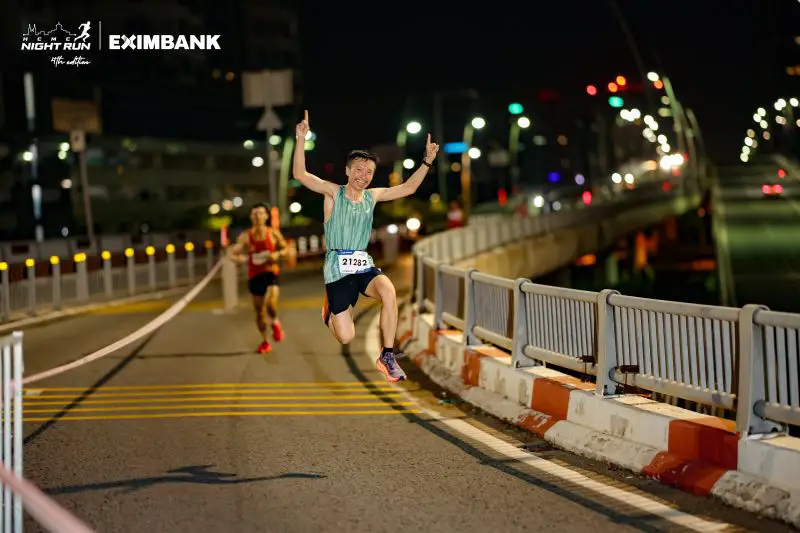 Justin Huynh, Life Of Doing, jumps on the bridge on the way to the HCMC Night Run finish line