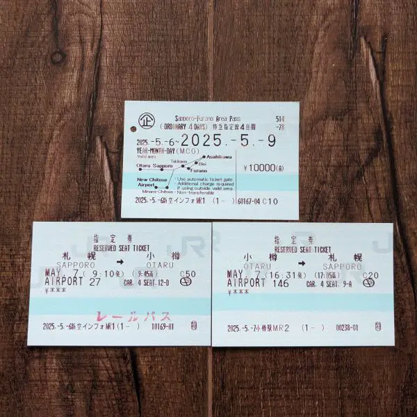 Three tickets - one is the Japan Railway Sapporo Furano Area Pass and the other two are reserved seat tickets from Sapporo to Otaru and Otaru to Sapporo