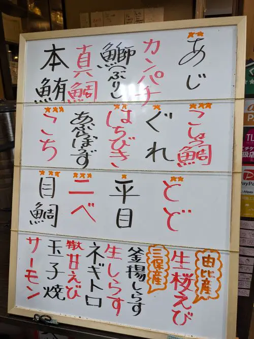 A whiteboard written in Japanese of the fresh fish of the day at Shimizu Fish Market's Donbei restaurant