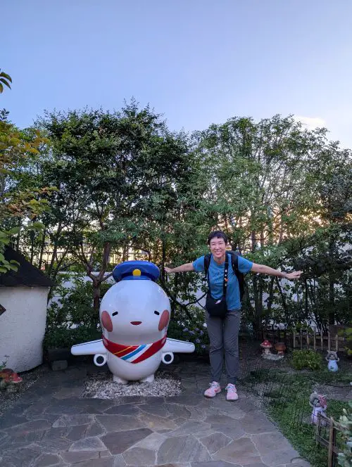 Jackie Szeto, Life Of Doing, poses with the Kansai airplane mascot, Sorayan, at the Osaka Itami Airport Observation deck area