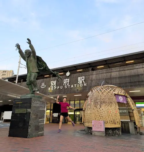 Jackie Szeto, Life Of Doing, jumps in front of the Beppu Station entrance and next to the Aburaya Kumahachi Statue