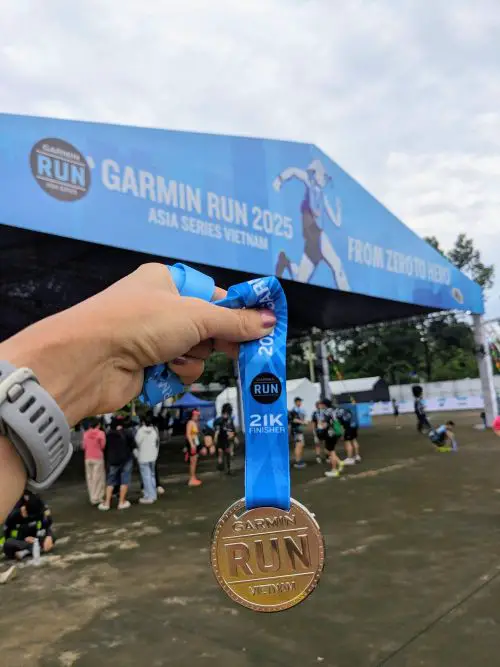 A hand holding the Garmin Asia Vietnam 21km finisher's medal