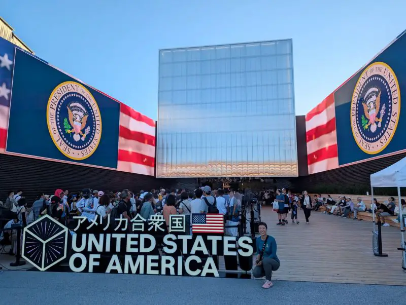 Jackie Szeto, Life Of Doing, crotches next to the United States of America sign at the Osaka Expo