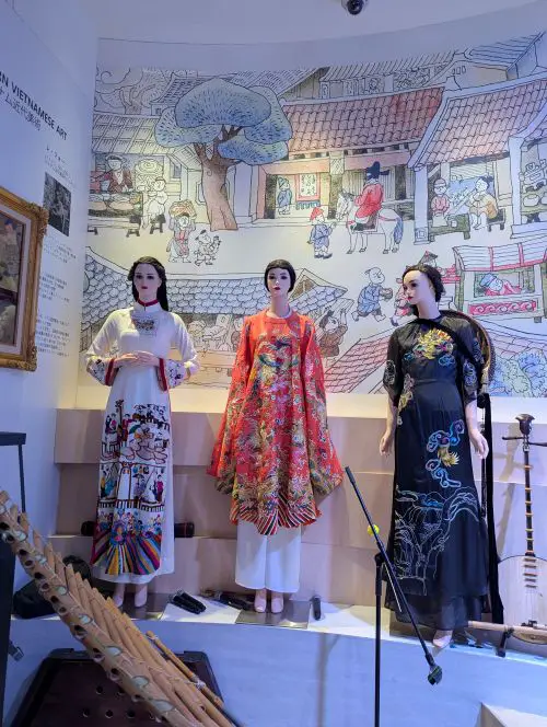 Three models wearing traditional Vietnamese outfits (ao dai)
