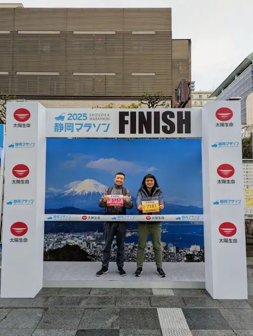 Justin Huynh, Life Of Doing, and a friend stand at a Shizuoka Marathon Finish Line photo spot at the Expo