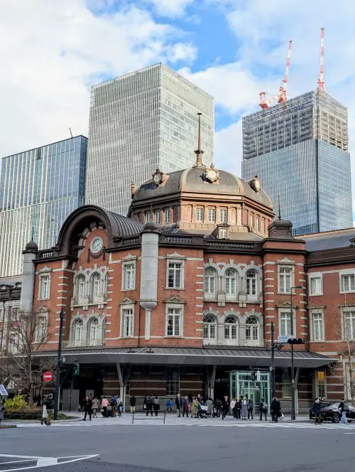 People walk in front of the red brick Tokyo Station in Tokyo, Japan