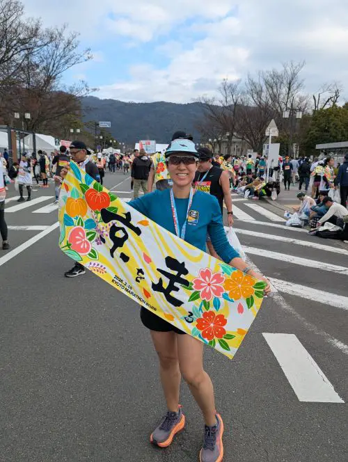 Jackie Szeto, Life Of Doing, finishes the Kyoto Marathon and holds the finisher towel