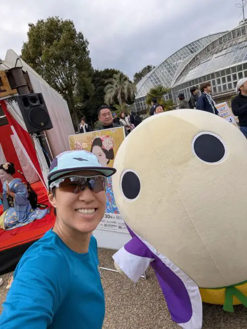 Jackie Szeto, Life Of Doing, stands next to Mayumaro, the Kyoto Public Relations silkworm mascot