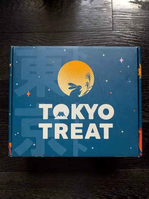 A blue cardboard box with the text, Tokyo Treat, and a design of a rabbit and a moon